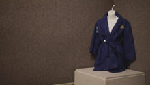 Load and play video in Gallery viewer, The Polar Express robe. The words "The Polar Express" are embroidered on upper left while the right bottom pocket features a bell design and "Believe" video
